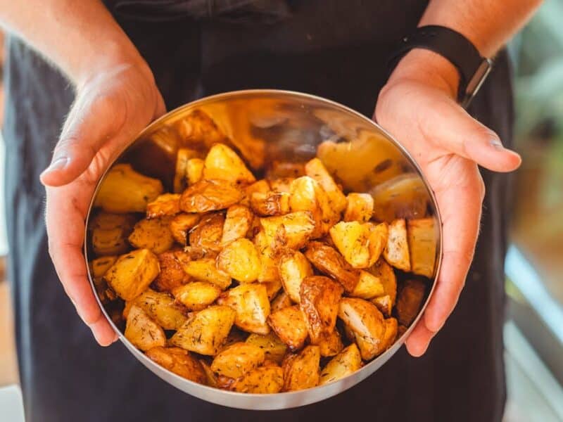 crop person with bowl of tasty potato