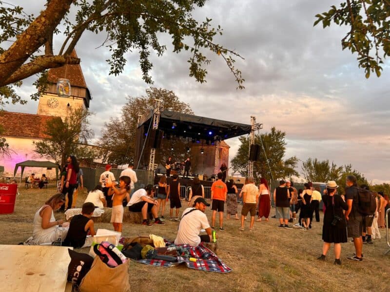 publicul urmărește un concert pe scena principală a festivalului holzstock, lângă biserica fortificată din hosman